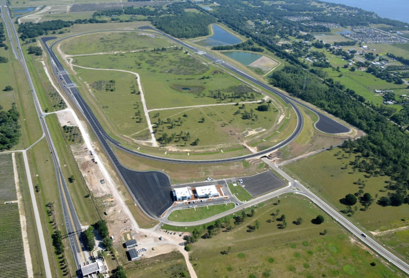 An aerial view of a race track near a lake.